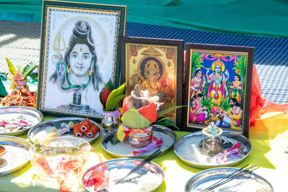 Altar with framed pictures, a coconut kalash and offerings