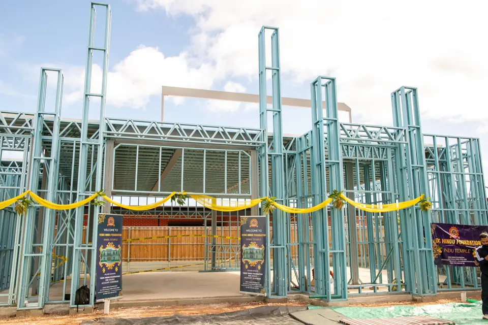 The temple’s steel frame dressed with yellow swags and mango leaves